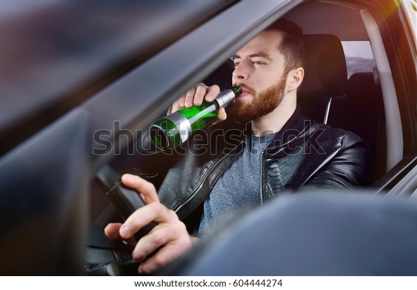 Drinks alcohol in the car.\
The guy with beer at the wheel. Man with beer. emergency situation.\
Social