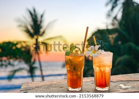 drinks with blur beach and sunset in background