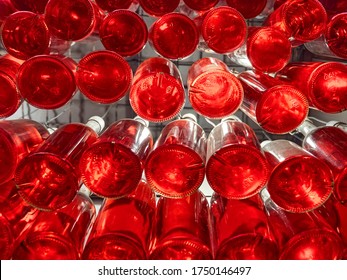 Drinks Bottled And Stored Together. Bottles Of Red Beverage Stored On Special Shelf. Alchohol, Non-alchohol Drinks In Bar, Restaurant. View From Below. Bottles Of Wine In Winery. Beverage Industry