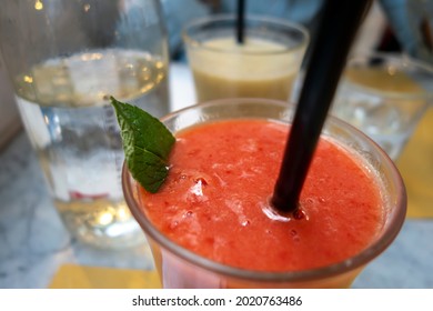 drinks with mint and black straw close up on a table. brand clear and tan color