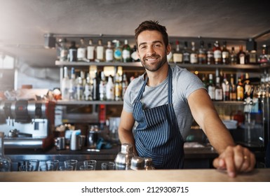 Drinks On Me. Portrait Of A Confident Young Man Working Behind A Bar Counter.