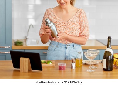 Drinks And People Concept - Close Up Of Woman With Shaker And Tablet Pc Computer Making Cocktail At Home Kitchen