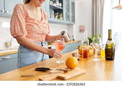 Drinks And People Concept - Close Up Of Woman Pouring Soda From Tin Can To Wine Glass And Making Orange Cocktail At Home Kitchen