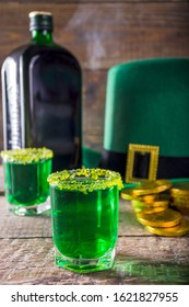 Drinks For St. Patrick's Day Party. Good Luck Leprechaun Shot Cocktail. Green Strong Drink In A Shot Glass With Gold Decor.