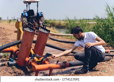 Drip Irrigation System. Water Saving Drip Irrigation System Being Used In A Young Strawberry Field. Worker Opens The Tap. Agricultural Background