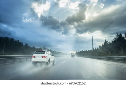 Drive Car In Rain On Asphalt Wet Road. Clouds And Sun.