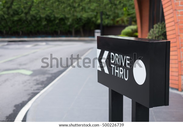 Drive thru sign\
with shop and road\
background.