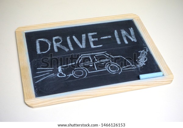 Drive-in movies sign on chalkboard with car             \
               