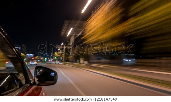 Drivelapse from side of fast car\
moving on a night avenue in city timelapse hyperlapse, road with\
lights reflected on car on high speed. Rapid rhythm of a modern\
city.