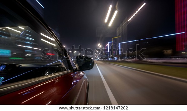 Drivelapse urban\
look from fast driving car at a night avenue in a city timelapse\
hyperlapse, road with lights reflected on car at high speed. Rapid\
rhythm of a modern\
city.
