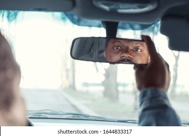 Driver Adjusting Rear View Mirror In Car