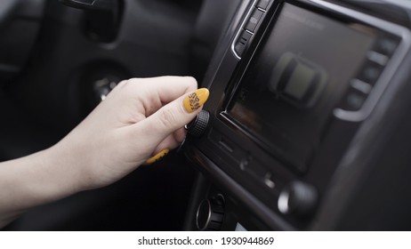 The Driver Adjusting The Volume Of A Radio Inside A Car. Action. Close Up Of A Woman Hand With Yellow Manicure Turning Volume Control, Details Of A Car Interior.