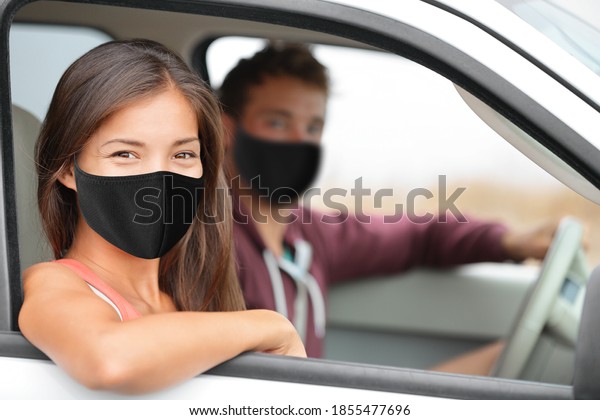 Driver and Asian passenger woman wearing\
face masks happy portrait in car driving buying new car or\
instructor with driver for test at driving\
school.