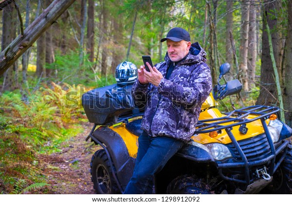 Driver ATV.\
Traveler in the forest. A man paves the route for travel.\
Navigation in the forest. Tourist paves the route on the phone.\
Maps navigation on mobile devices.\
ATV