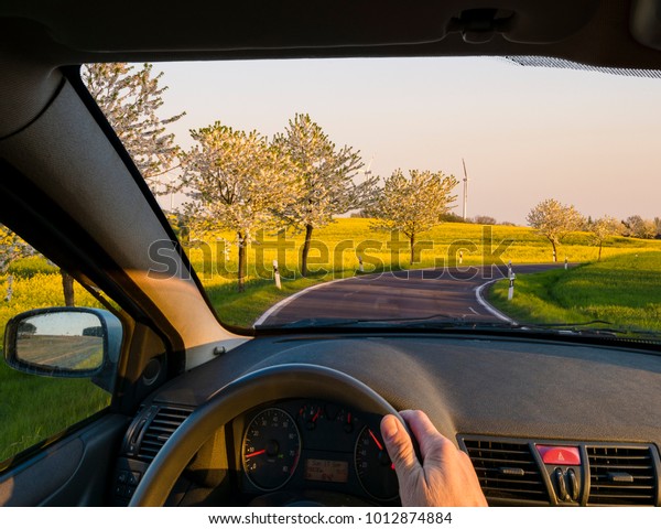 driver
behind the wheel driving down a country
road