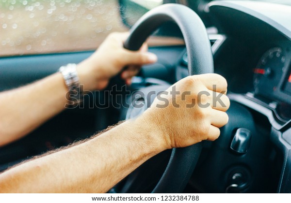 Driver with both\
hands at the wheel of the\
car.