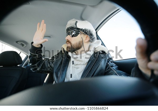 driver of the car in winter clothes, man behind\
the wheel, a winter journey on car,  brutal man with  beard on the\
car,  professional\
traveler
