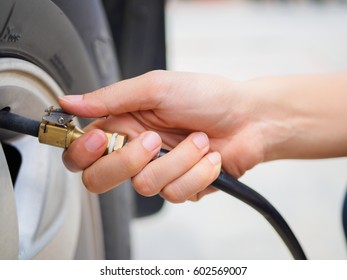 driver checking air pressure and filling air in the tires close up - Shutterstock ID 602569007