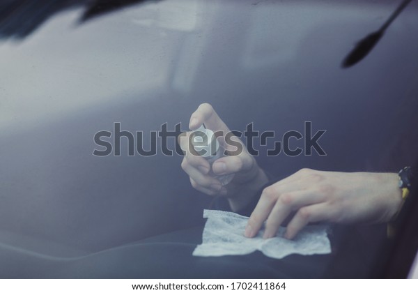the driver cleans the car interior with an\
alcohol-based antibacterial spray. protection against the spread of\
coronovirus infection