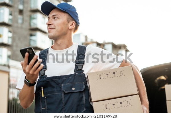 The driver of the courier service.\
Fast delivery of the goods. Employee in uniform logistics company. \
Delivery of a box of products and goods to your\
home.
