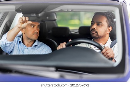driver courses and people concept - man and driving school instructor adjusting mirror in car