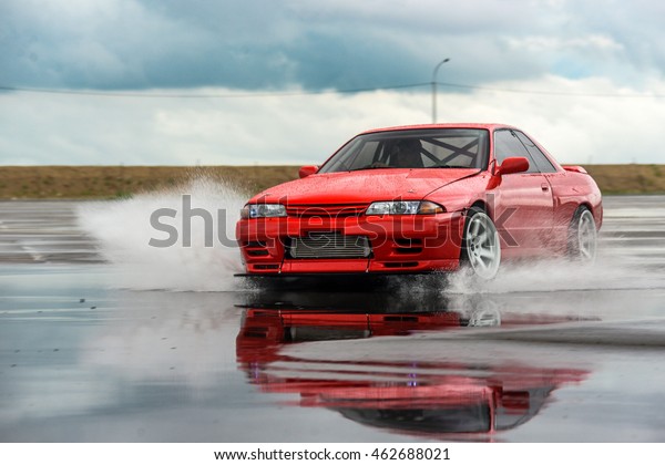 driver drives a Nissan skyline R 32\
red, on a wet road 9 July 2016 in Khabarovsk,\
Russia
