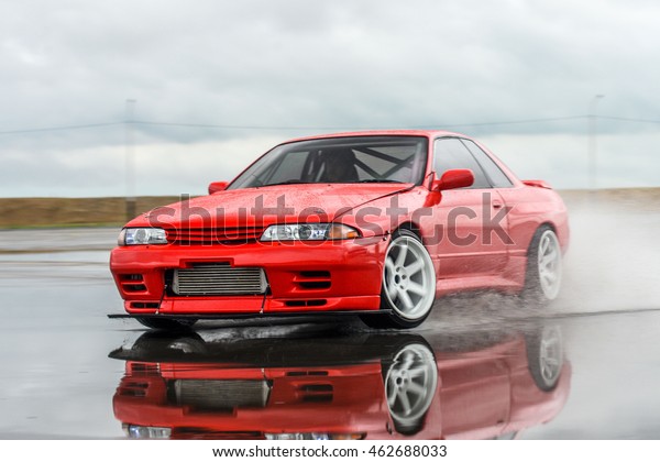 driver drives a Nissan skyline R 32\
red, on a wet road 9 July 2016 in Khabarovsk,\
Russia