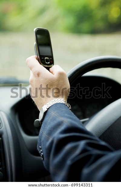 A driver\
driving a car and reading text\
message