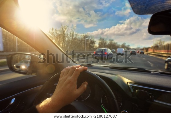 driver
is driving his car in the city on a beautiful
day