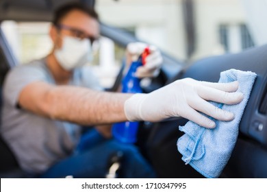 Driver With Face Surgical Mask Using Disinfectant And Microfiber Cloth To Clean Car Interior.