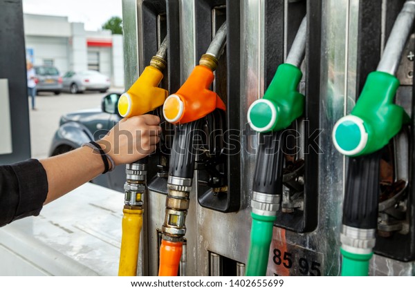 Driver fills the car with gasoline at the
gas station. Hand on the filling gun
close-up
