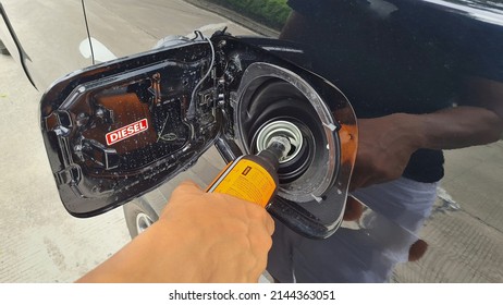 A Driver Fills A Diesel Additive Into A Car's Diesel Fuel Tank To Increase The Cetane Number And Lower The Sulfur Content Of Biodiesel