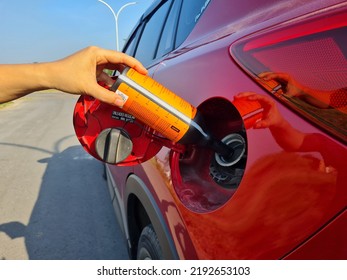 a driver fills a diesel additive into a car's diesel fuel tank to increase the cetane number and lower the sulfur content of biodiesel - Shutterstock ID 2192653103