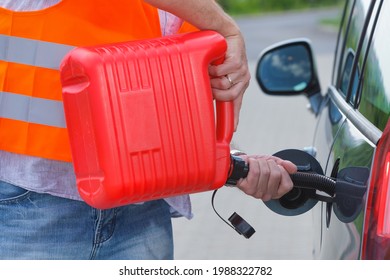 Driver Fills The Fuel In An Empty Car Tank From Red Canister On The Side Of The Road