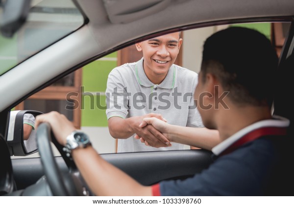 driver and friend or\
customer shake hand