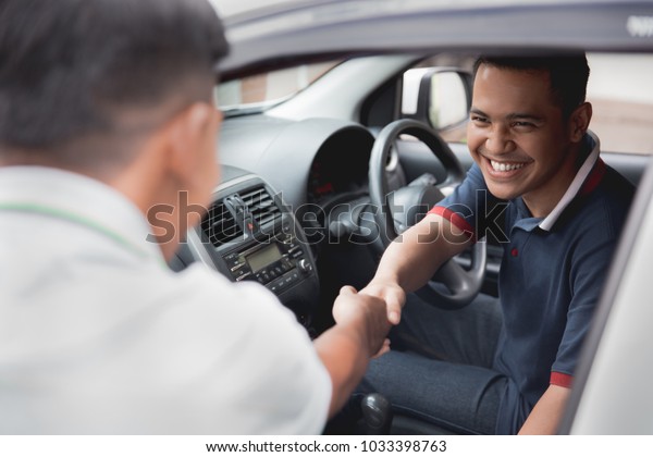 driver and friend or\
customer shake hand