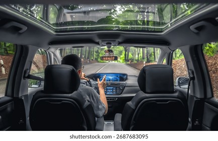 Driver gesturing while driving through forest road. Talking on the move.