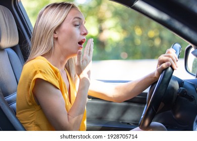 driver girl yawns while driving a car