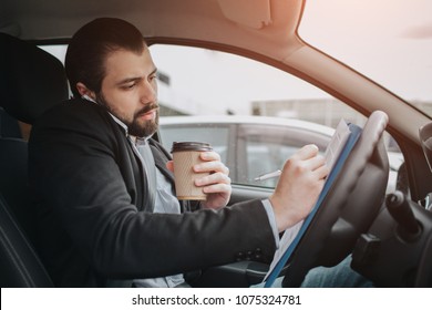 The Driver Going On The Road, Speaking On The Phone, Working With Documents At The Same Time. Businessman Doing Multiple Tasks. Multitasking Business Person.