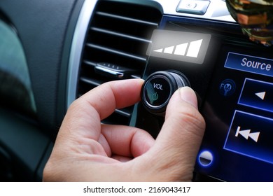 Driver hand adjust volume control on the car radio dashboard - Shutterstock ID 2169043417