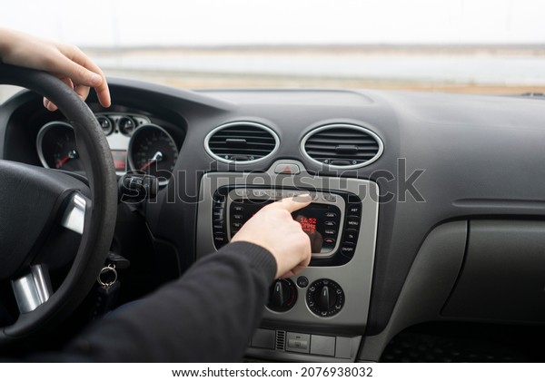 driver hand\
adjusting car multimedia, turn on\
radio