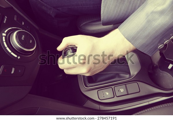 driver hand shifting the\
gear stick