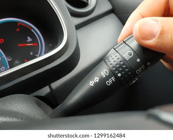 Driver hand using car turn signal stick/blinker switch
