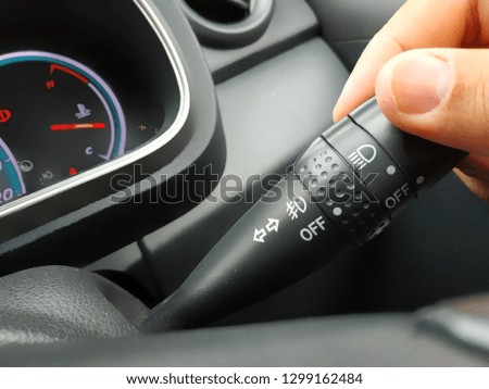 Driver hand using car turn signal stick/blinker switch