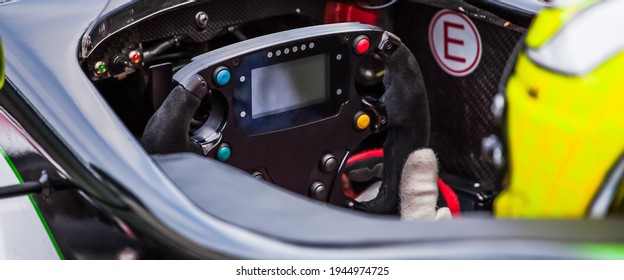 A Driver Holds The Steering Wheel Of His Supercar