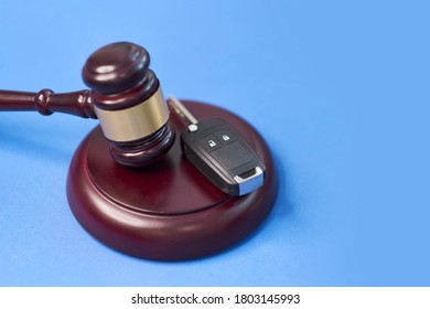 Driver license revocation concept next to the judge hammer. Traffic violation concept by car next to judge hammer. Revocable trust on a wooden desk.