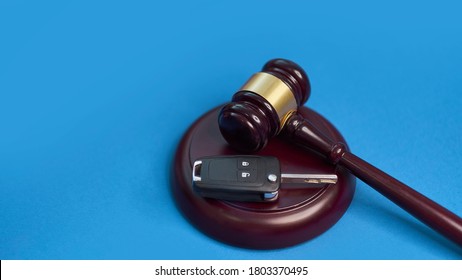Driver license revocation concept next to the judge hammer. Traffic violation concept by car next to judge hammer. Revocable trust on a wooden desk.