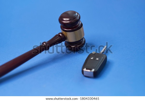 Driver license revocation concept next to\
the judge hammer. Traffic violation concept by car next to judge\
hammer. Revocable trust on a wooden\
desk.