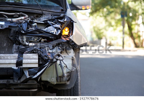 Driver man looking on\
wrecked car in car accident. Man regrets about fixing car headlight\
after auto crash. Tragedy car collision. Dangerous road traffic\
situation