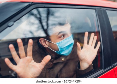 Driver Man Sitting In Car Wearing Protective Mask Scared Of Sick Flu Coronavirus People Outside. People Panic. Pandemic